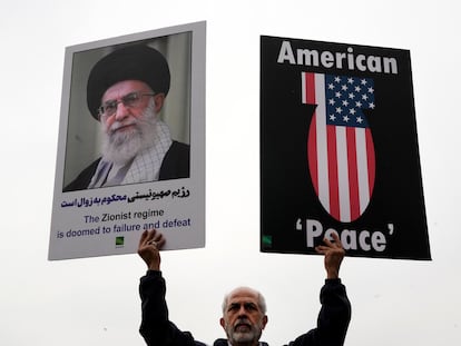 Un iraní sostiene dos carteles con la imagen del líder supremo del país, el ayatolá Ali Jamenei, y una bomba con la bandera de Estados Unidos, el pasado 28 de marzo en Teherán.