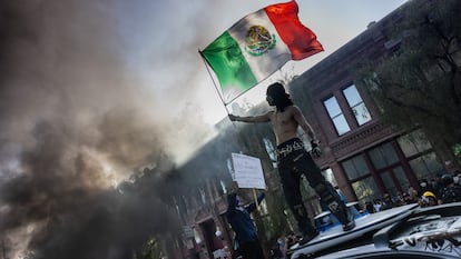 Un manifestante ondea la bandera de México.