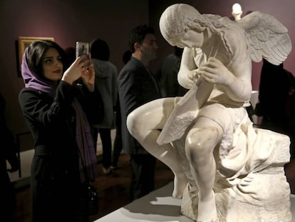 Una mujer junto a la escultura 'Funerary Genius' en la exposici&oacute;n 'El Louvre en Teher&aacute;n', inaugurada el 5 de marz&oacute; en Teher&aacute;n. 