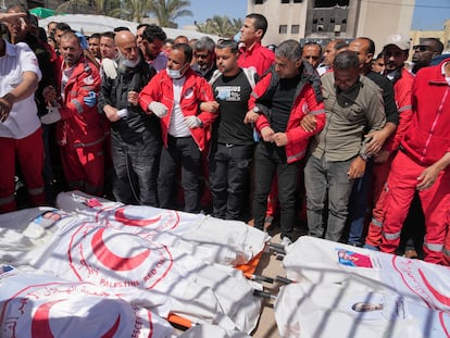 Mourners gather around the bodies of 8 Red Crescent emergency responders, recovered in Rafah a week after an Israeli attack, as they are transported for burial from a hospital in Deir al-Balah, Gaza Strip, on Monday, March 31, 2025. (AP Photo/Abdel Kareem Hana)