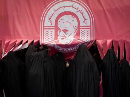 Un grupo de jóvenes iraníes, bajo un retrato del ex comandante de la fuerza Al Quds, del Cuerpo de Guardianes de la Revolución Islámica, en Teherán.