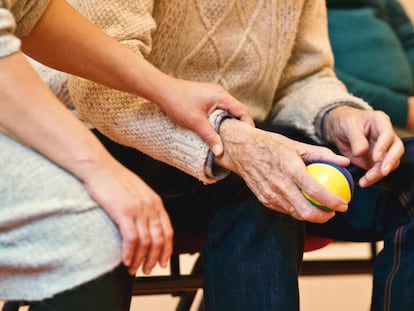 Un enfermo de alzhéimer junto a un familiar, en una residencia. 