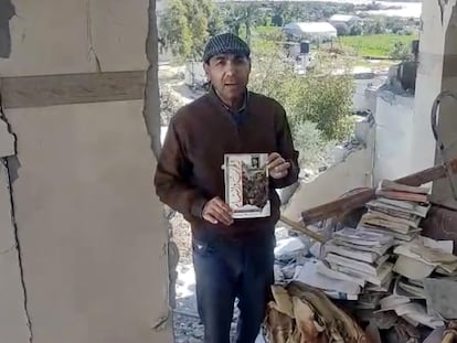 El poeta palestino Nasser Rabah enseña los pocos libros que pudo salvar de la biblioteca de su casa, bombardeada en 2024 por los tanques israelíes en el campo de refugiados de Al Maghazi, en el centro de Gaza. Imagen tomada el 9 de junio de 2025.