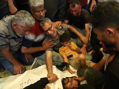 Ata Qasas (en el centro) llora el cuerpo de su hijo Rashad Qasas, quien murió mientras se dirigía a un centro de distribución de comida, durante su funeral en Rafah, al sur de la franja de Gaza, este miércoles.