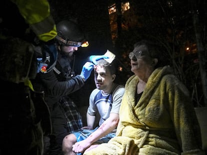 Personal sanitario curan a dos heridos tras un ataque ruso en la ciudad de Zaporiyia, este jueves. 