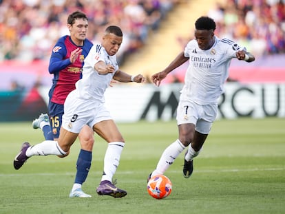 Mbappé y Vinicius tratan de controlar un balón en el clásico.