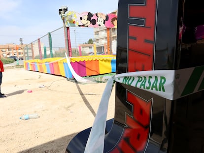 Un hombre observa las camas elásticas del recinto ferial de Alquerías donde una niña de dos años ha fallecido tras recibir una descarga eléctrica, este domingo.
