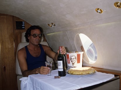 Julio Iglesias se dispone a comer a bordo de un avión privado, en Miami, en 1986.
