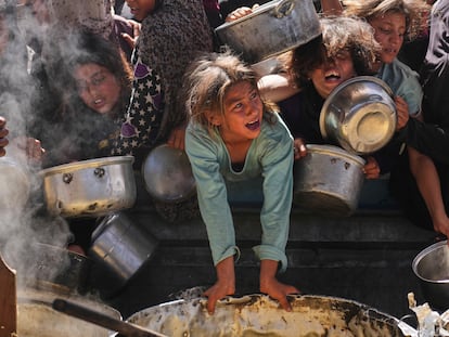 Niños palestinos tratan de hacerse con una ración de comida en un reparto de alimentos en Jan Yunis este viernes. 