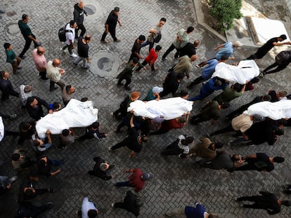 Cadáveres de palestinos muertos bajo las bombas israelíes durante un funeral en el hospital Al-Ahli, este martes en Ciudad de Gaza.
