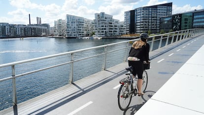 Una mujer pedalea por un puente solo para bicis en Copenhague.
