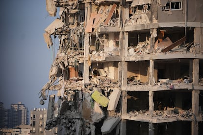 Fuerzas de seguridad inspeccionan un edificio destruido tras ser alcanzado por un misil iraní, en las cercanías de Tel Aviv, este domingo.