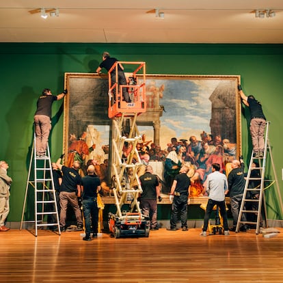 Colgado de 'Cena en casa de Simón'. A la izquierda, Miguel Falomir, comisario de la muestra y director del Prado, observa atentamente el proceso.
