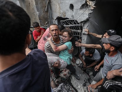 Un miembro de los equipos de rescate transporta a una niña herida en un bombardeo sobre el campo de refugiados de Yabalia, en el norte de Gaza, este domingo.