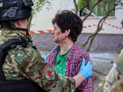 Una policía consuela a una mujer herida en un ataque ruso en una zona residencial en Zaporiyia, en Ucrania este martes.