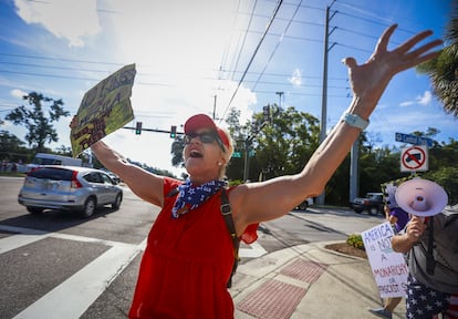 Kimberly Tichenor, de 58 años y residente de Palm Harbor, canta mientras ondea un cartel en Largo, Florida. 