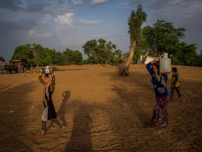 Unas mujeres transportan agua en un campo de refugiados cerca de Hamidiyeh, en el suroeste de Irán, en una imagen de abril de 2019.