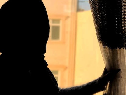 Una mujer afgana mira por la ventana de su casa en Herat, Afganistán en 2004, en una fotografía cedida.