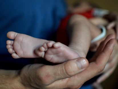 Un padre con su bebé, nacido por vientre de alquiler, en una imagen de archivo. 