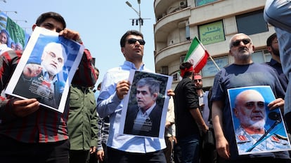 Un grupo de personas muestra imágenes de los científicos Mohammad Mehdi Tehranchi (izquierda) y Fereydoun Abbasi-Davani (centro) y del general Gholam Ali Rashid (derecha), muertos en el ataque de Israel, el viernes durante una protesta en Teherán. 